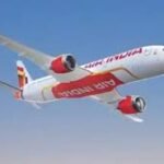 नीले आसमान में सफेद बादलों के बीच उड़ान भरता एयर इंडिया का यात्री विमान