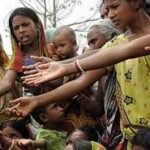 "एक गरीब व्यक्ति की तस्वीर जो सहायता की उम्मीद में हाथ फैलाए हुए है। पृष्ठभूमि में आधुनिक इमारतों और सड़कों का धुंधला दृश्य विकास और गरीबी के बीच के विरोधाभास (Contradiction) को स्पष्ट करता है, जो विश्व बैंक की 'जीवन स्तर' वाली रिपोर्ट के संदर्भ को मजबूती देता है।"