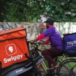 Delivery executive riding a bicycle with Swiggy and Zepto delivery bags, highlighting India’s growing quick commerce and e-retail sector.