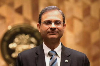 आरबीआई गवर्नर संजय मल्होत्रा मौद्रिक नीति समीक्षा के दौरान रेपो रेट 5.25% पर स्थिर रखने की घोषणा करते हुए, वैश्विक आर्थिक अनिश्चितताओं के बीच “वेट एंड वॉच” रणनीति पर जोर देते हुए दिखाई दे रहे हैं।